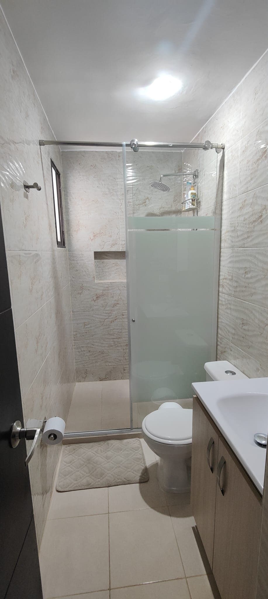 Un altro bagno, con il box doccia in vetro e il mobile lavabo in legno