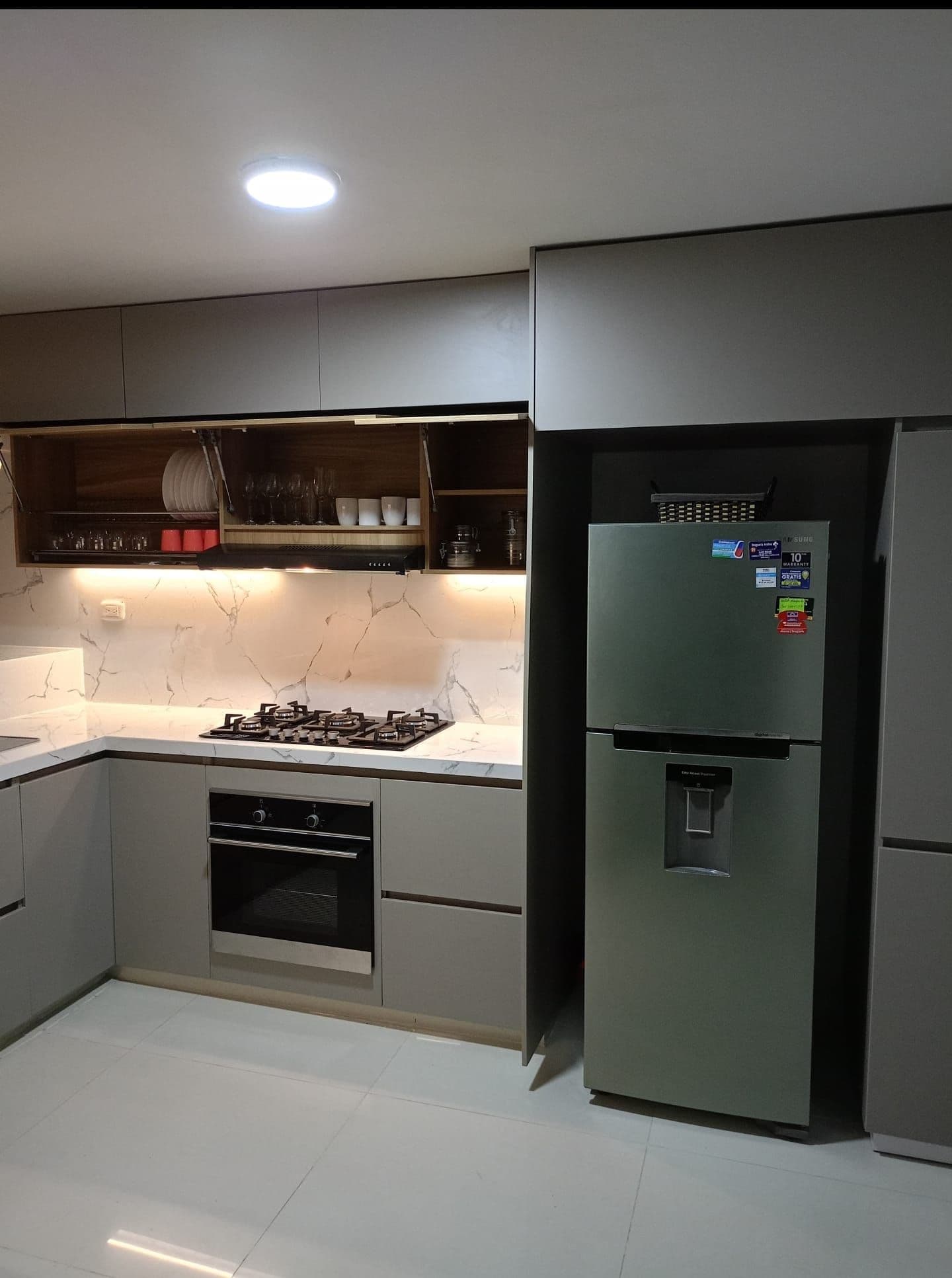 La cucina con il piano cottura a gas, il forno a incasso e il frigorifero